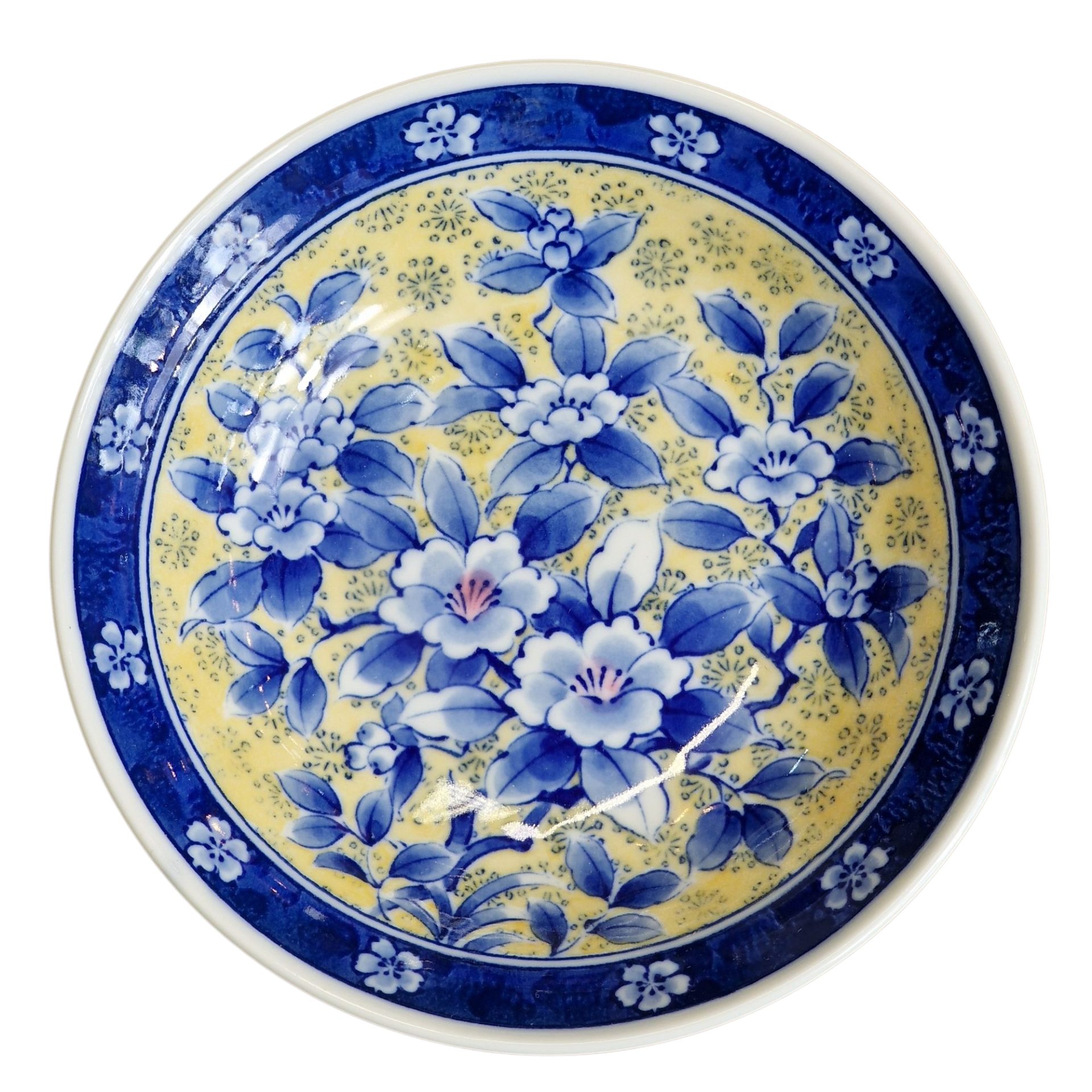 Prato decorativo de porcelana com padrão floral em azul sobre fundo amarelo, com inscrição na base.