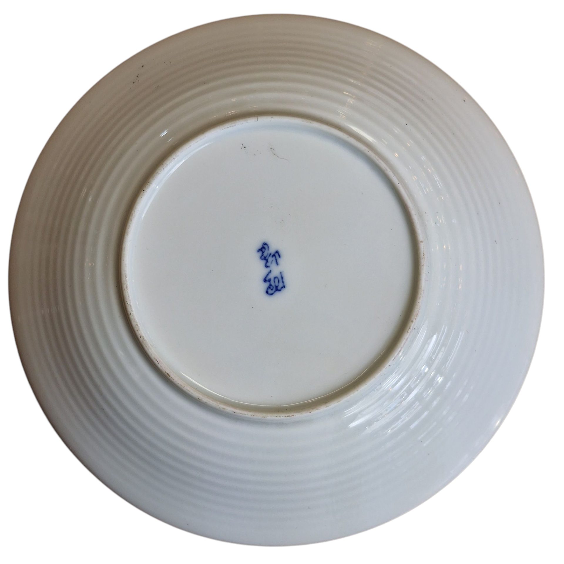 Prato decorativo de porcelana com padrão floral em azul sobre fundo amarelo, com inscrição na base.